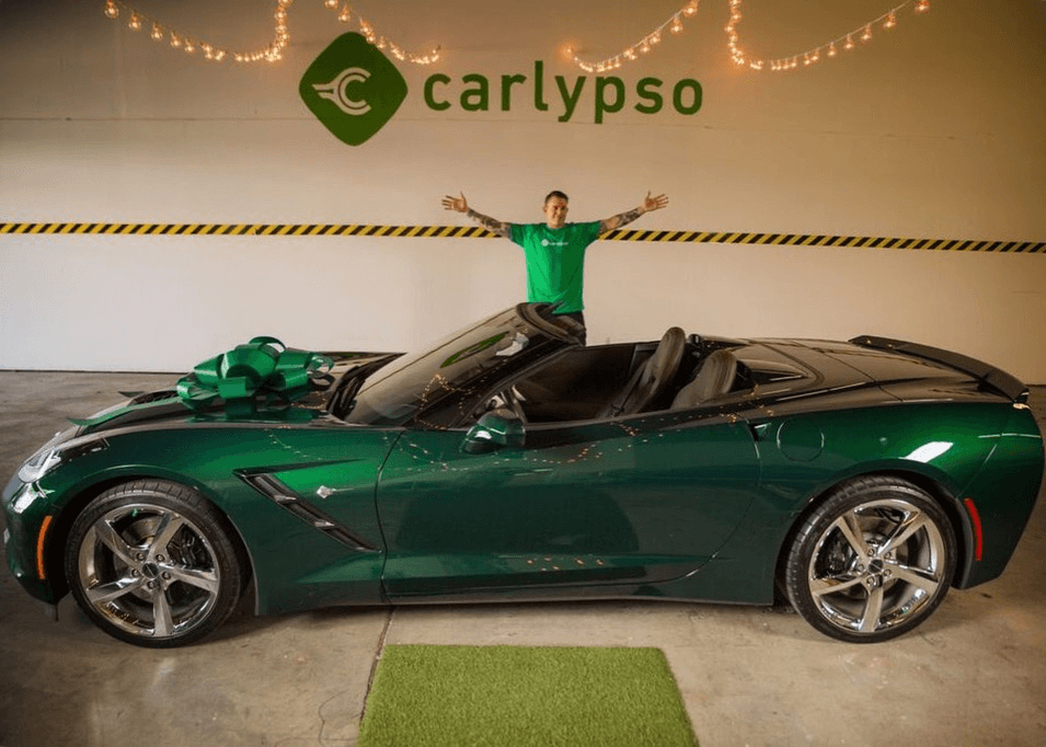 Joseph Audette celebrating in a green Corvette under the Carlypso garage sign